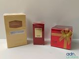 deux boîtes de parfum et une boîte de savon posées sur une surface blanche