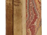 deux vieux livres sont empilés l'un sur l'autre sur une surface blanche