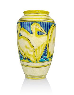 a yellow vase with a bird on it on a white surface