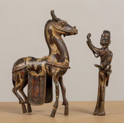 une statue représentant un cheval et un homme debout l'un à côté de l'autre