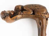 a close up of a wooden walking stick with a baby on it