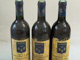 trois bouteilles de vin posées sur une table l'une à côté de l'autre