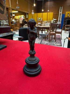 a statue of a child on a pedestal on a red carpet
