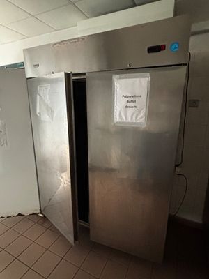 une photo d'un réfrigérateur en acier inoxydable dans une cuisine professionnelle