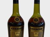 deux bouteilles de vin posées l'une à côté de l'autre sur une surface blanche