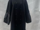 an image of a woman ' s black coat on display in front of a white backdrop