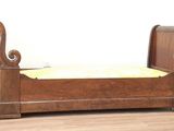 un lit en bois recouvert d'une couverture jaune