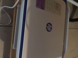 a white and blue laptop sitting on top of a shelf