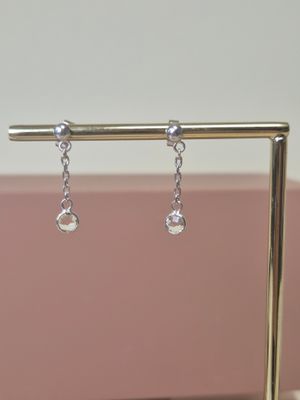 boucles d'oreilles plaquées argent ornées de cristaux transparents suspendus à un support
