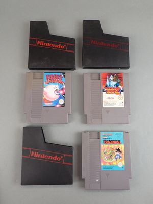 Quatre cartouches de jeux Nintendo sont alignées sur une table