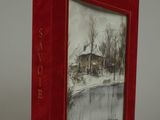 a red book with a picture of a house in the background