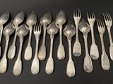 eight silverplated forks and spoons on a black surface