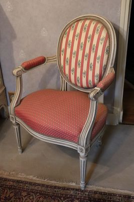 a red and white striped chair sitting in front of a fireplace