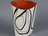 un vase noir et blanc avec un bord rouge