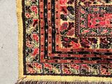 an old rug hanging on a wall next to a pair of scissors