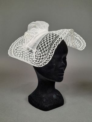 un gros plan sur la coiffe d'un mannequin coiffée d'un chapeau blanc