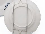 a white plate with a metal holder attached to it