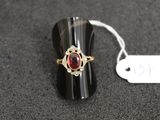 a ring with a red stone on it and a price tag