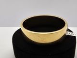 une bague en or posée sur un porte-bague noir