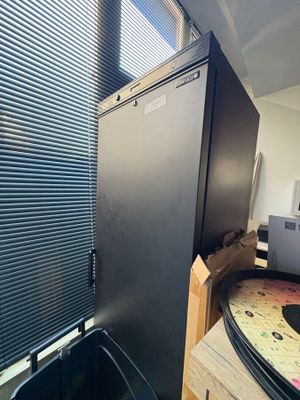 a black refrigerator in the corner of a room