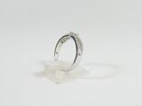 a close up of a diamond ring on a white surface