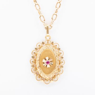 un collier Locke en or avec une pierre rose entourée d'une chaîne