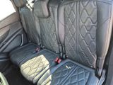 the back seats of a car with black leather and a red seat belt