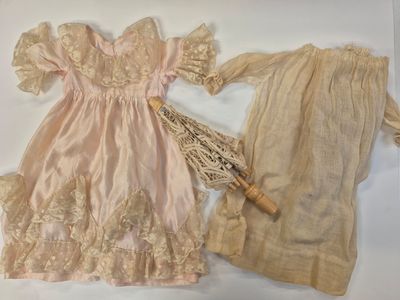two dresses and an umbrella sitting on a table