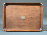 an old wooden tray with a small metal button on it
