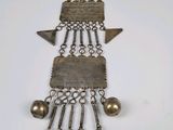 an old silver necklace with bells and bells hanging from it ' s chain
