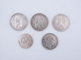 four silver coins are arranged in a row on a white surface