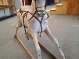 a wooden rocking horse that is on display in a store