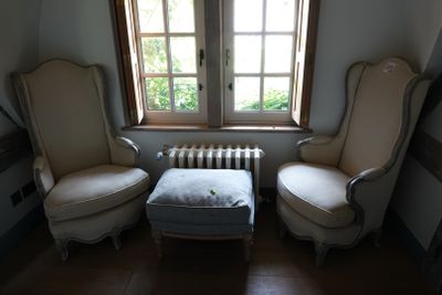 deux chaises et un pouf dans un coin de la pièce