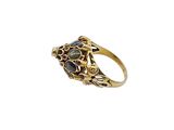 a close up of a gold ring with black stones on it