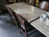 des tables et des chaises dans une pièce avec une cheminée en arrière-plan