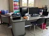 un bureau avec deux ordinateurs et une chaise dans une pièce