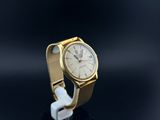 a close up of a gold wrist watch with a white strap