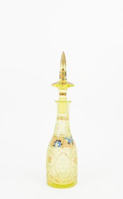 yellow glass perfume bottle with a gold top on a white background