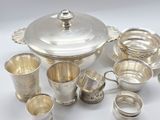 an assortment of silverware including cups, saucers, and spoons