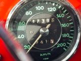 un gros plan sur le compteur de vitesse d'une moto rouge