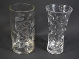 two glass vases sitting next to each other on a table