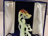 une figurine en verre représentant une femme tenant une fleur à la main
