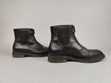 une paire de bottes en cuir noir sur fond blanc