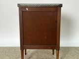 an image of a small wooden cabinet on a carpeted floor