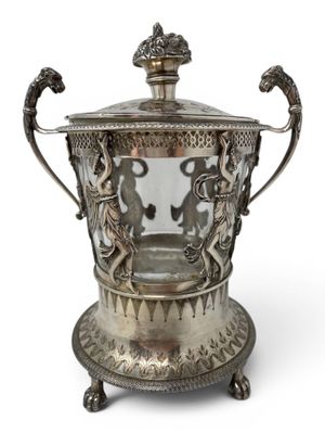 an antique silver plated ice bucket with two lions on it