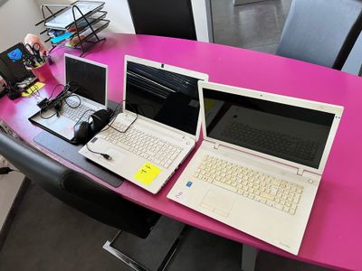 deux ordinateurs portables posés sur une table rose