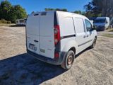 une camionnette blanche garée dans la poussière