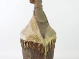 a small vase with a statue of a woman on it
