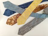 several different colored ties laid out on a white surface