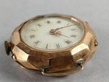 a gold watch with roman numerals on the face